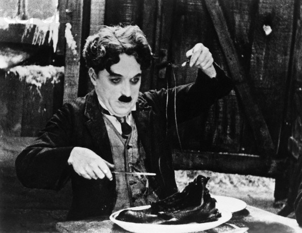 Charlie Chaplin in the Shoe-Eating Scene from <The Gold Rush>.